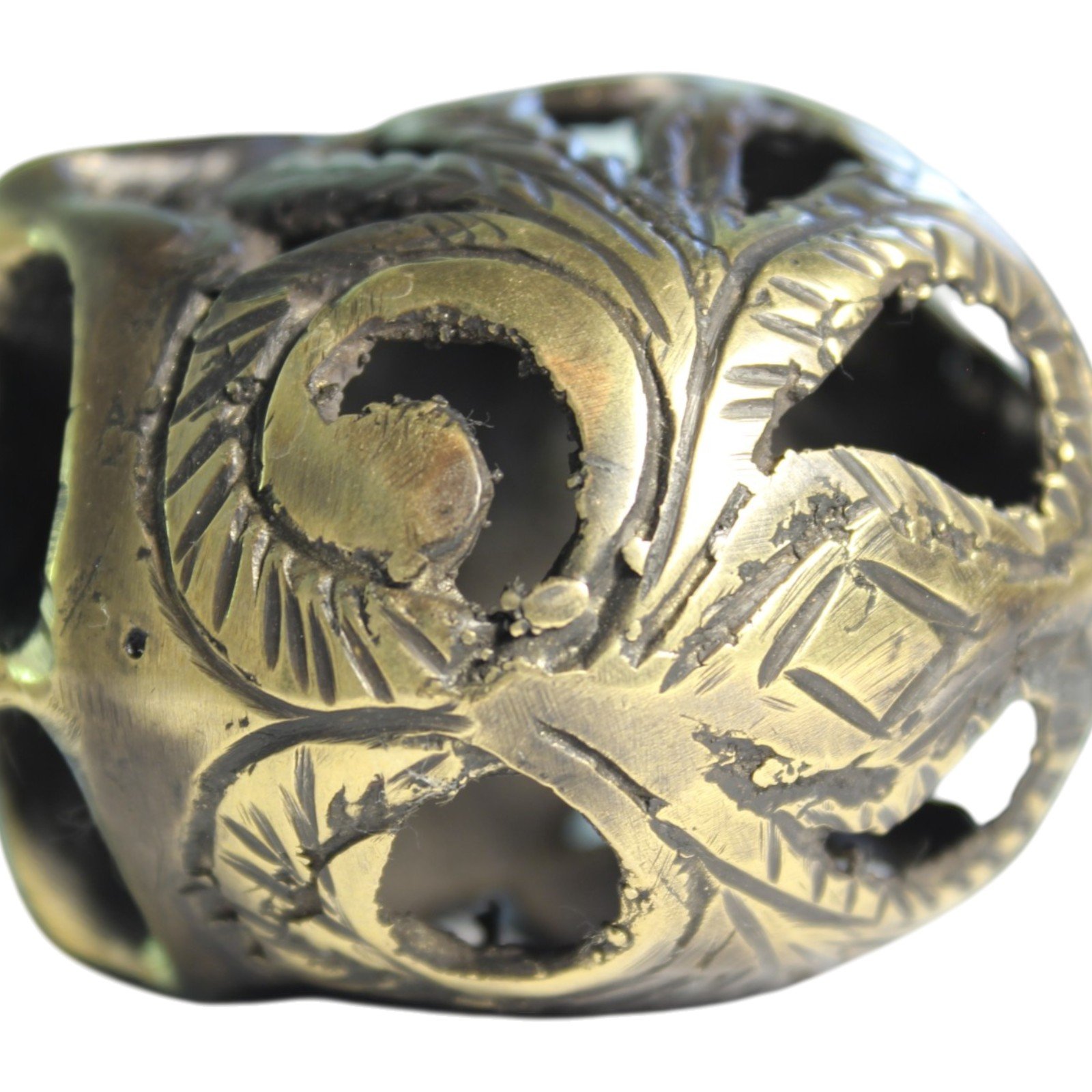 Handvara view of the brass skull figurine showing symmetrical carving and aged finish