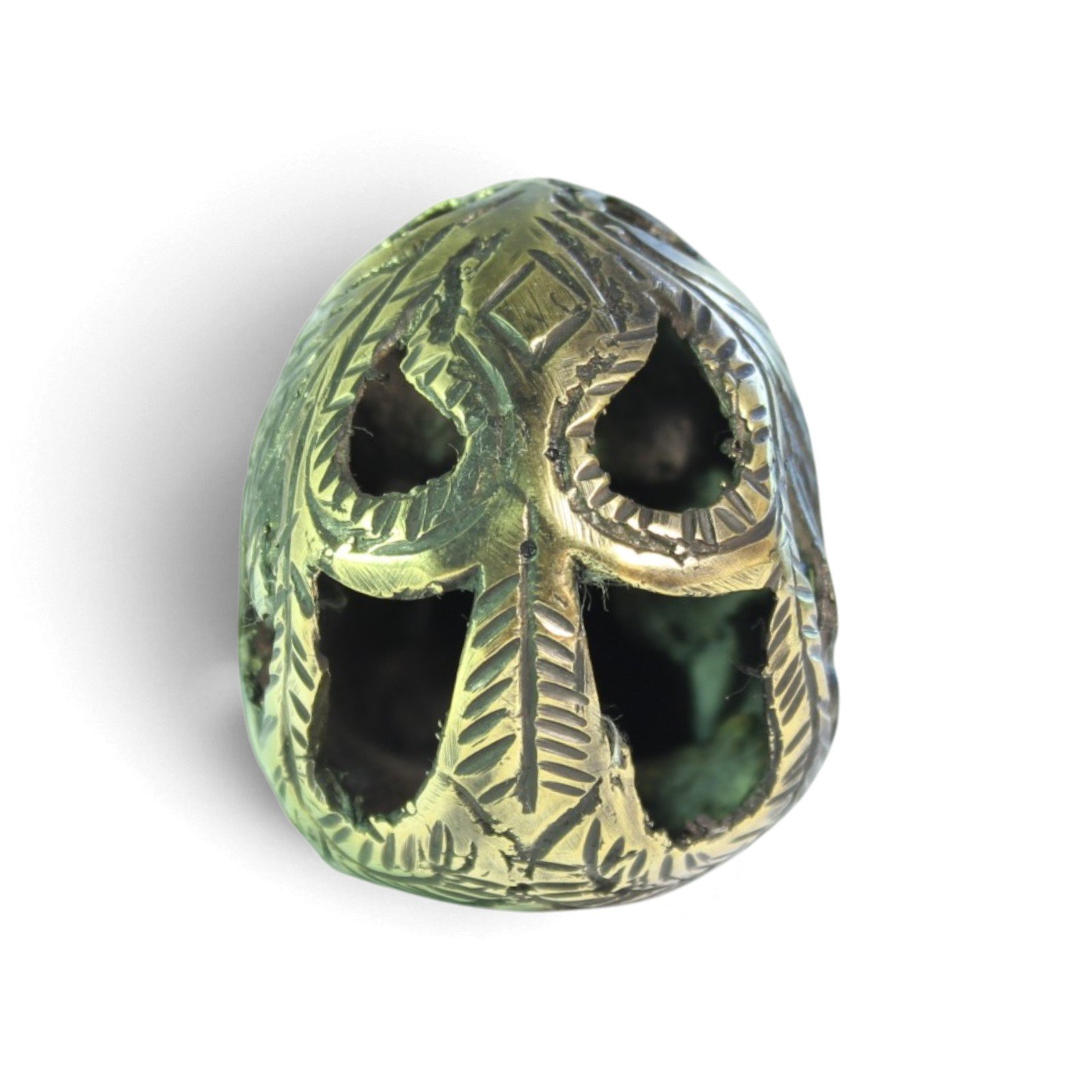 Handvara view of the brass skull figurine showing symmetrical carving and aged finish