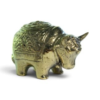 Solid brass bull figurine with patterned back, side view on white background