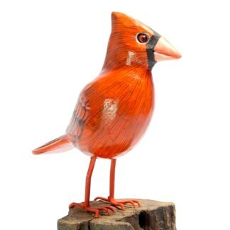 Hand-carved wooden cardinal figurine perched on a rough wood base, side view