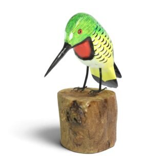 Hand-carved wooden hummingbird figurine with green and yellow painted body perched on a wood stump
